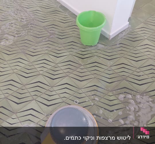 מכונת ניקוי רצפה ודלי ירוק על הרצפה